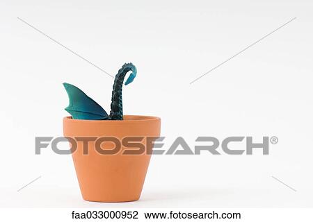 Toy dragon sticking out of terracotta pot View Large Photo Image Stock Image - Toy dragon sticking out of terracotta pot. Fotosearch