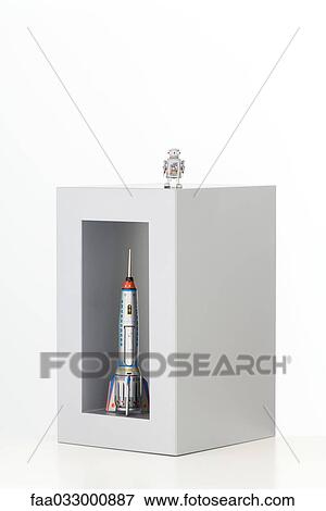 Toy robot standing on top of a box with a toy rocket standing up in it View Large Photo Image Stock Photo - Toy robot standing on top of a box with a toy rocket standing up in it. Fotosearch