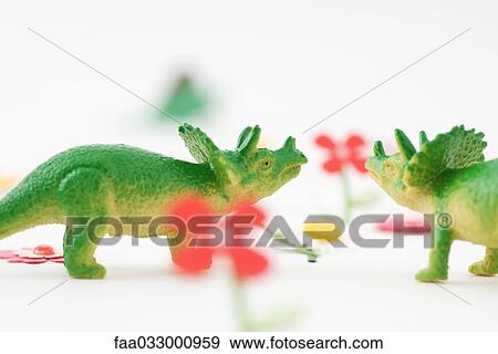 Stock Photo - Toy triceratops face to face in artificial garden. Fotosearch