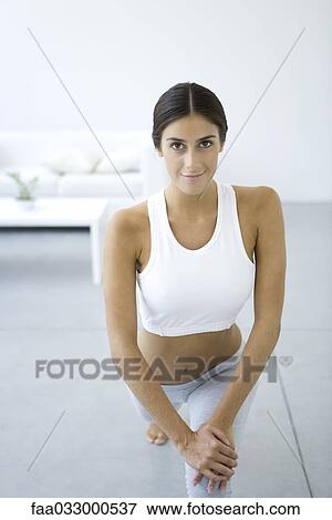 Stock Photo - Woman doing lunges, smiling at camera. Fotosearch