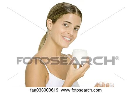 Woman holding open jar of moisturizer, smiling at camera View Large Photo Image Stock Photo - Woman holding open jar of moisturizer, smiling at camera. Fotosearch