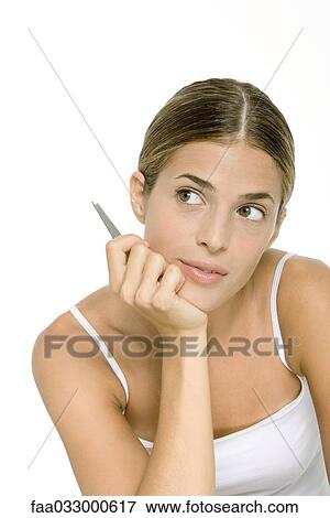 Woman holding tweezers, chin resting on hand, looking away View Large Photo Image Stock Photo - Woman holding tweezers, chin resting on hand, looking away. Fotosearch