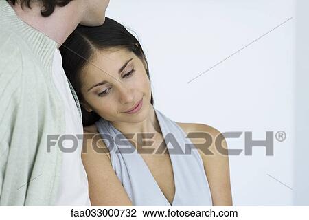 Woman leaning against man's chest, looking down and smiling View Large Photo Image Stock Image - Woman leaning against man's chest, looking down and smiling. Fotosearch