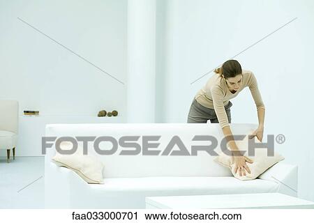 Woman leaning over couch, arranging pillow View Large Photo Image Stock Image - Woman leaning over couch, arranging pillow. Fotosearch