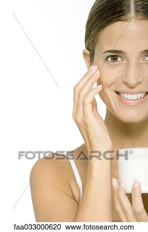 Woman moisturizing face, smiling at camera View Large Photo Image Stock Image - Woman moisturizing face, smiling at camera. Fotosearch