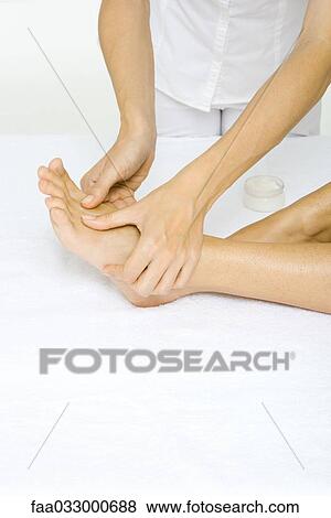 Stock Photo - Woman receiving foot massage, cropped view. Fotosearch