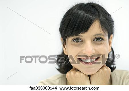 Woman smiling at camera, hands under chin, portrait View Large Photo Image Picture - Woman smiling at camera, hands under chin, portrait. Fotosearch