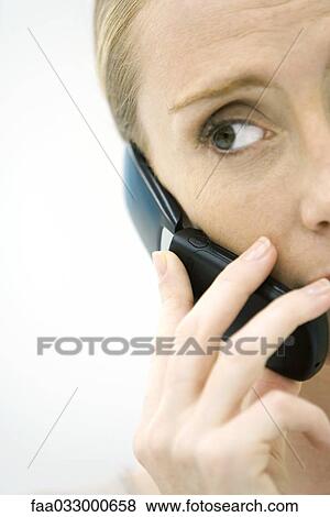 Woman using cell phone, looking away, cropped view View Large Photo Image Stock Photo - Woman using cell phone, looking away, cropped view. Fotosearch