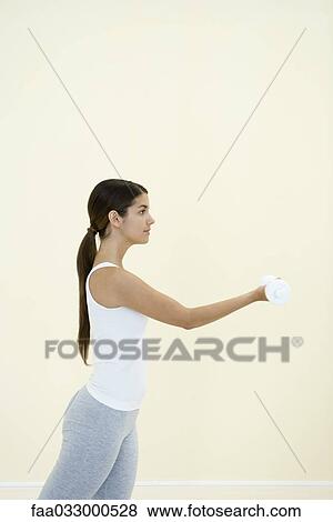 Young woman lifting weights, side view View Large Photo Image Stock Photo - Young woman lifting weights, side view. Fotosearch