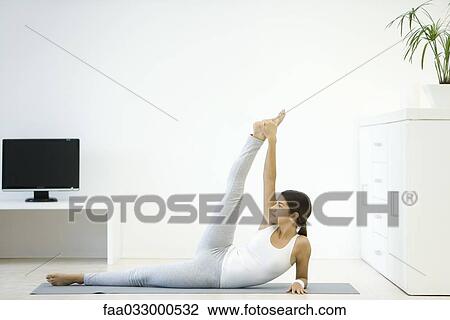 Young woman lying on the ground, stretching legs View Large Photo Image Stock Image - Young woman lying on the ground, stretching legs. Fotosearch