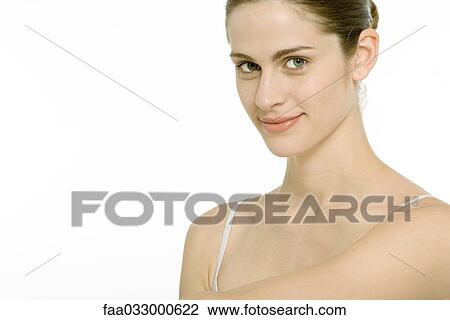 Stock Image - Young woman smiling at camera, portrait. Fotosearch