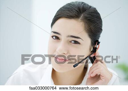 Picture - Young woman wearing headset, smiling at camera, portrait. Fotosearch