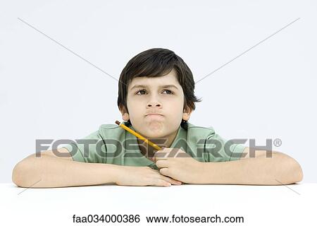 Boy holding pencil, biting lips, looking up View Large Photo Image Stock Photograph - Boy holding pencil, biting lips, looking up. Fotosearch