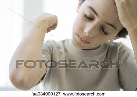 Stock Photo - Boy holding up elbow, eyes closed. Fotosearch