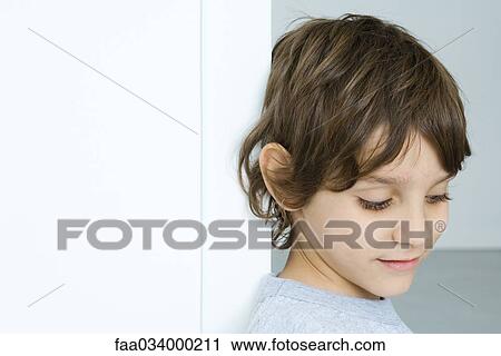Stock Image - Boy looking down, portrait. Fotosearch