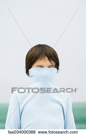 Stock Photo - Boy with turtleneck pulled over face, portrait. Fotosearch