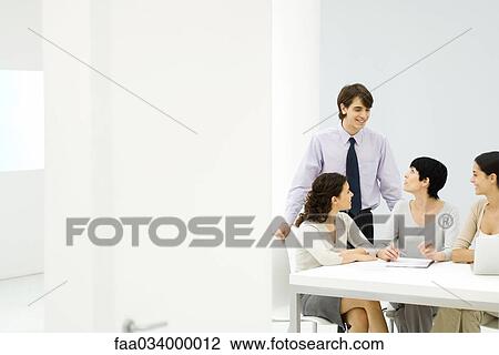 Stock Image - Business associates meeting, chatting. Fotosearch