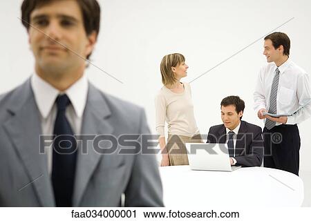 Business associates talking, man in foreground View Large Photo Image Stock Image - Business associates talking, man in foreground. Fotosearch