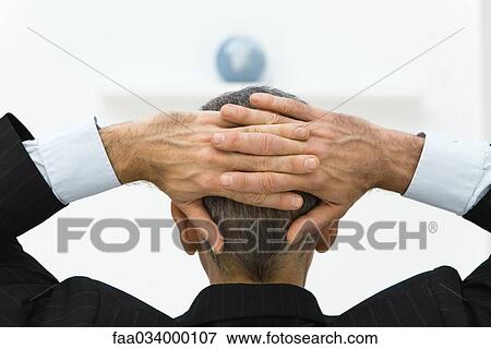 Business man with hands behind head looking at globe, rear view View Large Photo Image Stock Photo - Business man with hands behind head looking at globe, rear view. Fotosearch