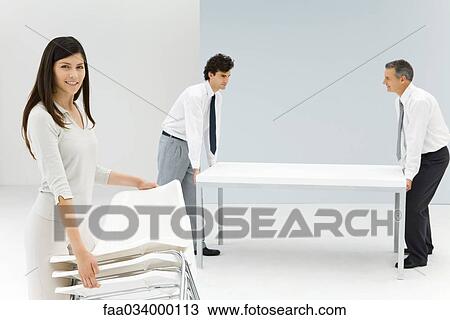 Business people moving furniture in office View Large Photo Image Stock Image - Business people moving furniture in office. Fotosearch