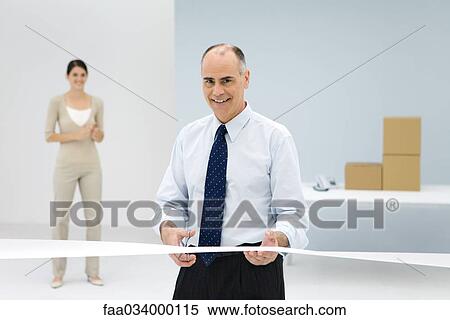 Businessman cutting opening day ribbon in office, smiling View Large Photo Image Stock Photography - Businessman cutting opening day ribbon in office, smiling. Fotosearch