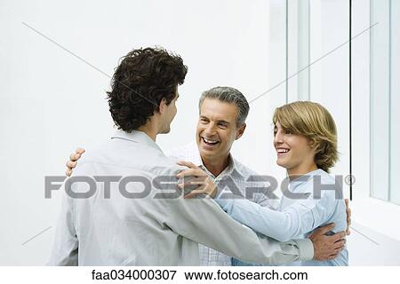 Father and two sons greeting each other, smiling View Large Photo Image Stock Photo - Father and two sons greeting each other, smiling. Fotosearch