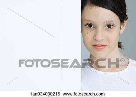 Stock Photography - Girl leaning against doorway, smiling, portrait. Fotosearch