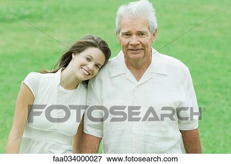 Stock Photo - Grandfather with teenage granddaughter, her head on his shoulder, both smiling. Fotosearch