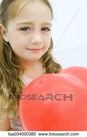 Little girl holding heart shaped balloon, close-up View Large Photo Image Stock Image - Little girl holding heart shaped balloon, close-up. Fotosearch