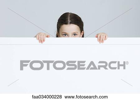 Stock Photo - Little girl peeking over ledge at camera. Fotosearch