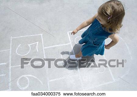 Stock Photography - Little girl playing hopscotch outdoors, overhead view. Fotosearch