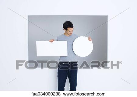 Man holding blank signs, looking down and smiling View Large Photo Image Stock Photo - Man holding blank signs, looking down and smiling. Fotosearch