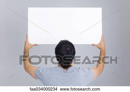 Man holding up blank sign, rear view View Large Photo Image Picture - Man holding up blank sign, rear view. Fotosearch