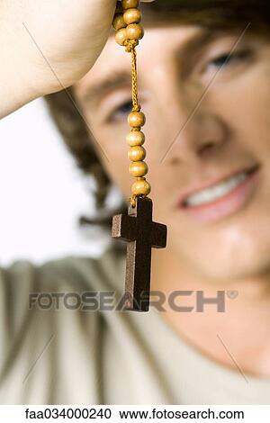 Man holding wooden rosary, focus on foreground View Large Photo Image Stock Image - Man holding wooden rosary, focus on foreground. Fotosearch