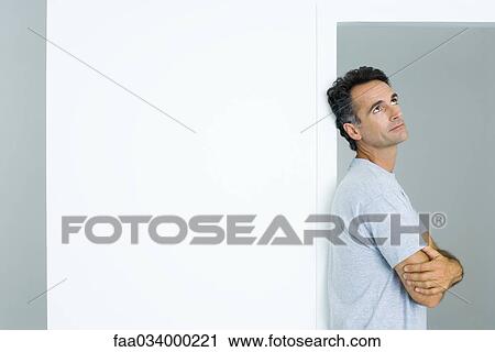 Man leaning against doorway with arms folded looking up View Large Photo Image Stock Image - Man leaning against doorway with arms folded looking up. Fotosearch
