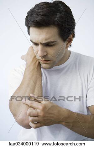 Man putting adhesive bandage on arm, frowning View Large Photo Image Stock Photo - Man putting adhesive bandage on arm, frowning. Fotosearch