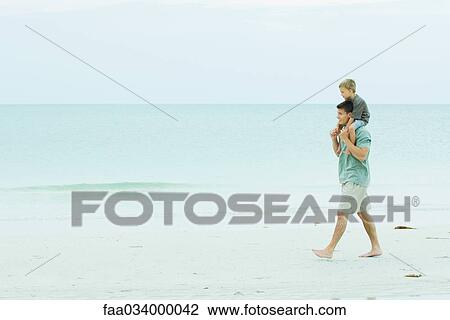 Man walking on empty beach carrying son on his shoulders View Large Photo Image Stock Image - Man walking on empty beach carrying son on his shoulders. Fotosearch
