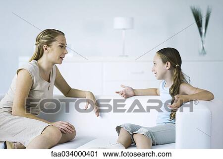 Mother and daughter seated face to face on sofa, talking View Large Photo Image Stock Image - Mother and daughter seated face to face on sofa, talking. Fotosearch