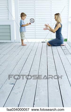 Stock Photo - Mother and son playing catch on porch. Fotosearch
