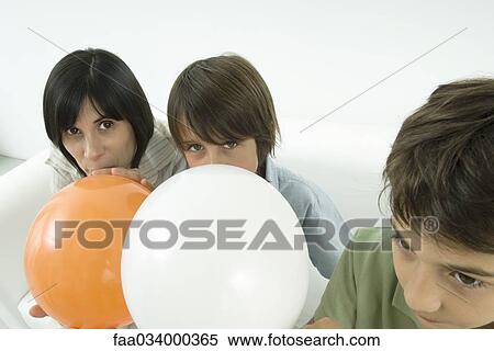Stock Photography - Mother and sons inflating balloons. Fotosearch