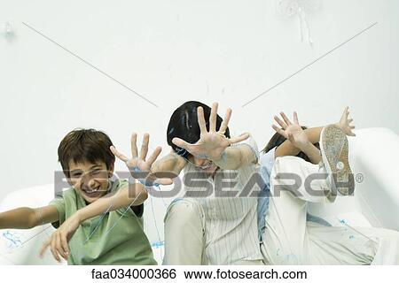 Mother and two sons being sprayed with party string, laughing, hands raised View Large Photo Image Stock Photograph - Mother and two sons being sprayed with party string, laughing, hands raised. Fotosearch