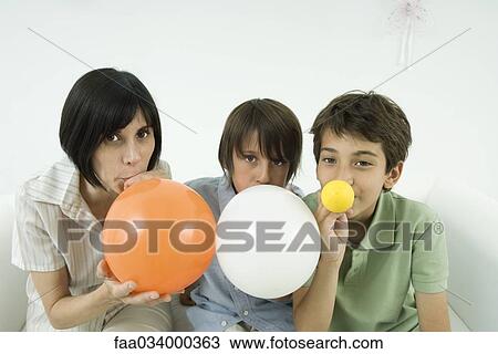 Mother and two sons inflating balloons, looking at camera View Large Photo Image Stock Image - Mother and two sons inflating balloons, looking at camera. Fotosearch