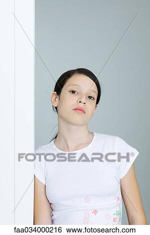 Stock Photograph - Preteen girl leaning against doorway, looking at camera. Fotosearch