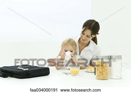 Professional woman sitting at breakfast table with toddler, briefcase nearby View Large Photo Image Stock Image - Professional woman sitting at breakfast table with toddler, briefcase nearby. Fotosearch
