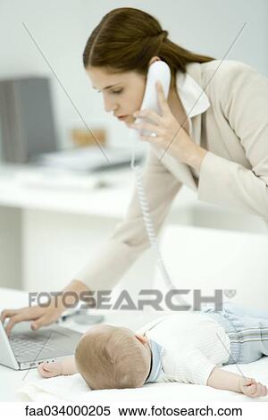 Professional woman using laptop computer and phone, infant lying on desk View Large Photo Image Stock Photography - Professional woman using laptop computer and phone, infant lying on desk. Fotosearch