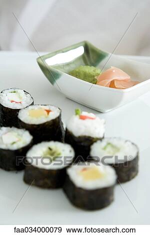 Stock Photo - Rows of maki sushi, dish of pickled ginger and wasabi. Fotosearch