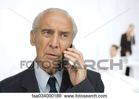 Senior businessman using cell phone, furrowing brow View Large Photo Image Stock Photo - Senior businessman using cell phone, furrowing brow. Fotosearch