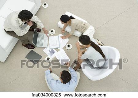 Team of professionals in casual work environment, discussing documents, overhead view View Large Photo Image Stock Photography - Team of professionals in casual work environment, discussing documents, overhead view. Fotosearch