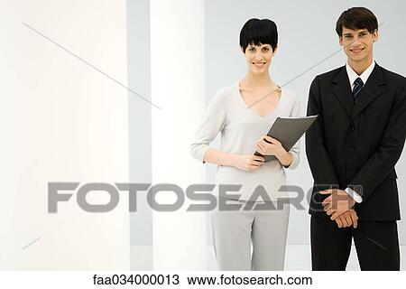 Stock Image - Two young business associates posing together, smiling. Fotosearch