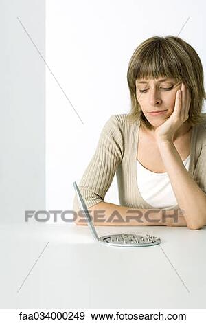 Woman contemplating electronic game, hand under chin View Large Photo Image Stock Photo - Woman contemplating electronic game, hand under chin. Fotosearch